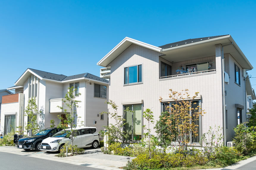 青空を背景に白い家が並んだ住宅街