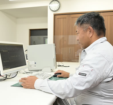 作業着を着た男女が会議をしている