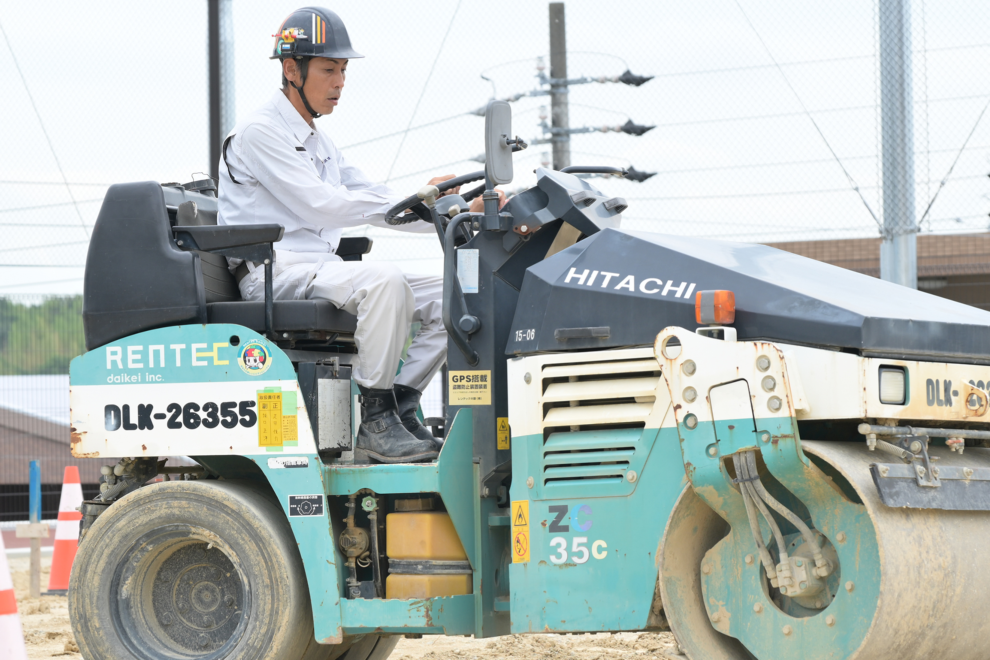 ヘルメットを被った男性がショベルカーを操作している